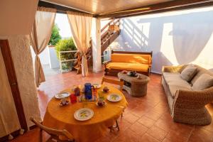 una sala de estar con una mesa y un sofá en Baia Marina Oasi, en Balestrate