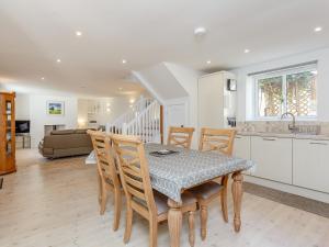 eine Küche und ein Esszimmer mit Tisch und Stühlen in der Unterkunft Willow Cottage - Uk39244 in Inverness