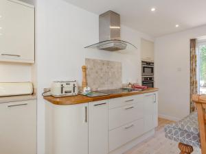 eine Küche mit weißen Schränken und einem Herd in der Unterkunft Willow Cottage - Uk39244 in Inverness + 15 Fotos