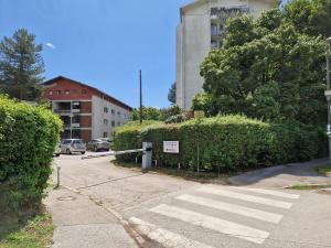 a street with a crosswalk in front of a building at Hostel Rožna dolina, Dom XIV in Ljubljana