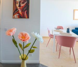 a vase with flowers in a room with a table at La Perle du Sud - Vue Mer Exceptionnelle in Villeneuve-Loubet +25 photos