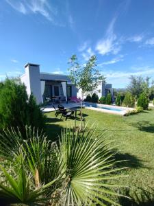 a villa with a garden and a swimming pool at Tres Deseos in Villa Cura Brochero