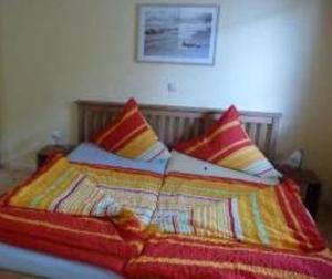 ein Bett mit bunten Decken und Kissen darauf in der Unterkunft Ferienwohnung Lino in Zinnowitz