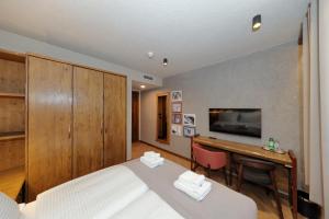 a bedroom with a bed and a desk and a television at Planinarski dom Vošac in Makarska