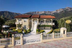 a house with a gate and mountains in the background at Villa Billena in Skala Potamias