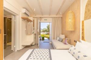 a bedroom with a bed and a couch in a room at Villa Billena in Skala Potamias