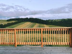 a wooden fence with a view of a field at DoPierro Domek in Dursztyn