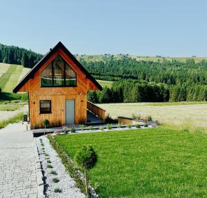 a small wooden house in a green field at DoPierro Domek in Dursztyn