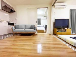 a living room with a couch and a flat screen tv at Rosenheim Tokyo Shinjuku in Tokyo