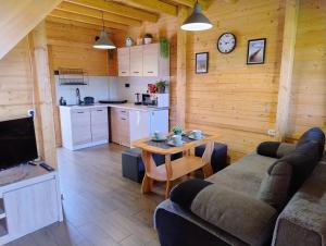 a living room with a couch and a table at Domki Bursztynowa Zatoka 2 in Sarbinowo