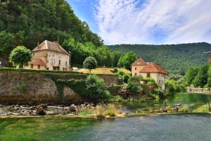 a group of buildings on the side of a river at Au fil de Lods in Lods