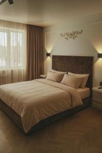 une chambre avec un grand lit et une fenêtre dans l'établissement Квартира, à Pavlodar