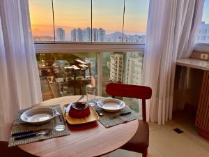 a table with a plate of food on top of a window at PRAIA Mar Sofisticado Novo in Vila Velha