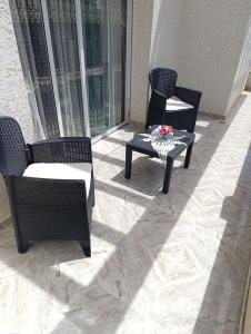 two chairs and a table on a patio at فيلا بمولاي بوسلهام in Kenitra +1 photo