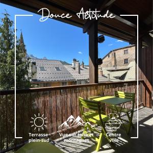 a patio with a table and chairs on a deck at Douce Altitude - Centre ville - Balcon in Barcelonnette