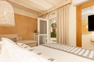 a bedroom with a bed and a sliding glass door at Villa Billena in Skala Potamias