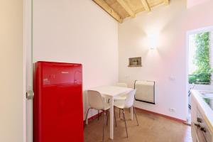 una porta rossa in una cucina con tavolo e sedie di Casa Lippa a Spilamberto