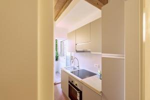 una cucina con mobili bianchi e un lavandino di Casa Lippa a Spilamberto