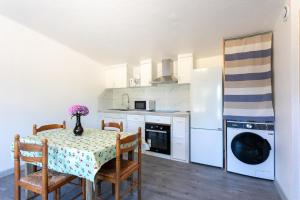a kitchen with a table and a white refrigerator at Glycine in Paimpol