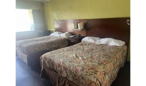 a hotel room with two beds and a window at Capitol Inn by Belvilla Richmond Airport VA in Sandston