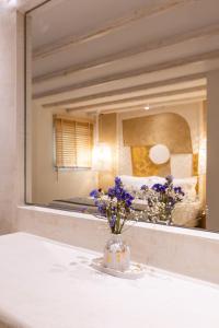 a vase of flowers on a table in front of a mirror at Villa Billena in Skala Potamias +73 photos