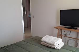 a room with a television and a bed with towels at Condominium in the Center of Calama in Calama