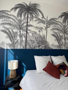 a bedroom with a bed with palm trees on the wall at Jean Jaurès - Centre Ville in Brest