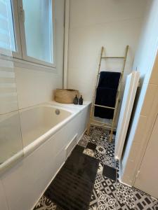 a bathroom with a tub and a towel rack at Jean Jaurès - Centre Ville in Brest