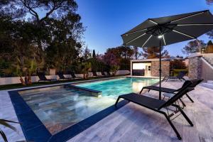 a swimming pool with a chair and an umbrella at Appart HOTEL 3 Chambres - parking - clim in Saint-Raphaël