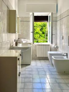 een witte badkamer met 2 wastafels en 2 toiletten bij Civico 20, Quiet Cozy Studio Air Condition in Mandello del Lario