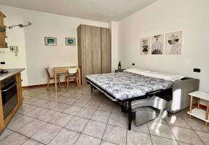 een kamer met een bed, een tafel en stoelen bij Civico 20, Quiet Cozy Studio Air Condition in Mandello del Lario