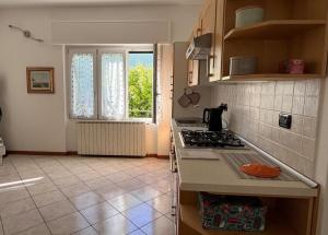 een keuken met een fornuis en een raam erin bij Civico 20, Quiet Cozy Studio Air Condition in Mandello del Lario