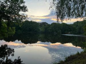 Una vista de un lago con árboles y una puesta de sol. en LA Combe, en Confolens 6 fotos más