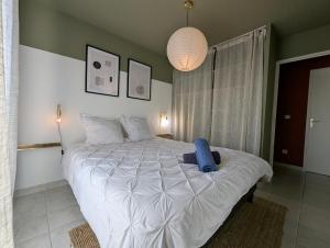 a bedroom with a large bed with a blue stuffed animal on it at Le Belvédère - Clim Terrasse Parking privé in Balaruc-les-Bains