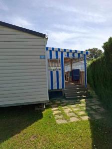 a blue and white building with a porch at 181-Charmettes in Les Mathes