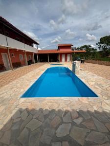 a large blue swimming pool in front of a building at Sítio vovó Joana 2 in Esmeraldas +15 photos