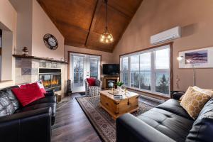Una sala de estar con un sofá y una chimenea. en 14 guests with SPA - Chalet LaPaix-Ski, en Petite-Rivière-Saint-François
