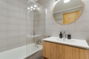 Un baño con lavabo, espejo y bañera. en Atlantic Dutchman, en Caniço