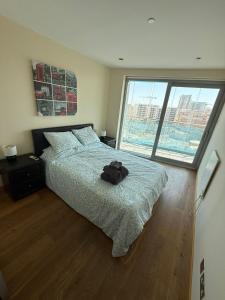 a bedroom with a large bed and a large window at 2 Bed Apt in Ocean Village - Pool - Rock View - Sleeps 4 in Gibraltar