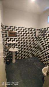 a bathroom with a black and white checkered wall at Green moonVillage in Ban Nok