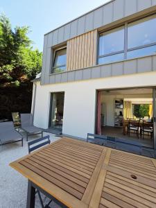 un patio con tavolo in legno di fronte a una casa di charmante maison a 300 m de la plage et du GR 34 a Landéda