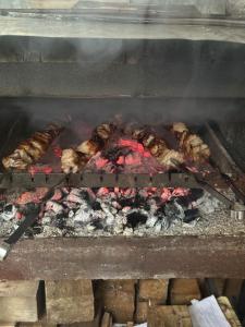 a bunch of meat cooking on a grill at Vardzia-Chachkari Cottage ,,SEFE" in Gogasheni