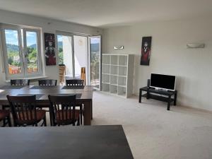 a living room with a dining room table and a television at Lakeview Apartment in Schluchsee