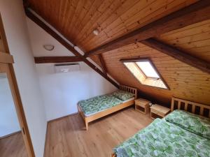 una camera mansardata con due letti e una finestra di U Lojzika a Pulkov