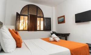 um quarto com uma cama com um cobertor laranja em Park Hotel em Santa Marta