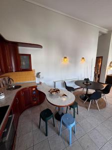 a kitchen with two tables and chairs in a kitchen at Naos Family House , Paralia Ofriniou in Ofrínion
