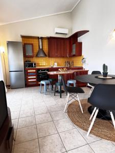 a kitchen with a table and chairs in a kitchen at Naos Family House , Paralia Ofriniou in Ofrínion +2 photos