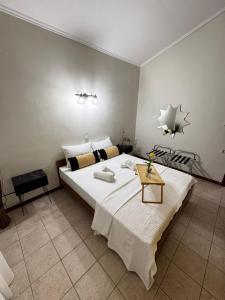 a bedroom with a large white bed and a table at Naos Family House , Paralia Ofriniou in Ofrínion