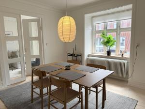 a dining room with a wooden table and chairs at Cozy pearl downtown Viborg in Viborg