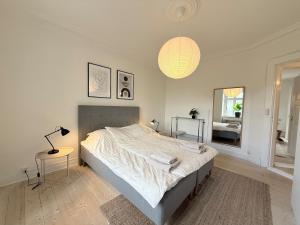 a bedroom with a bed and a lamp and a window at Cozy pearl downtown Viborg in Viborg